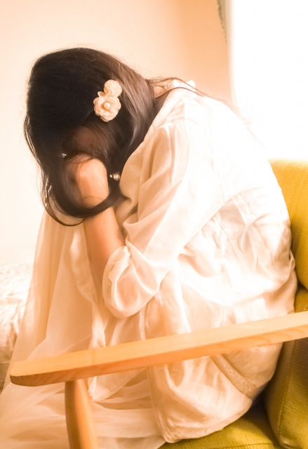 頭を抱える女性(斜め向き)